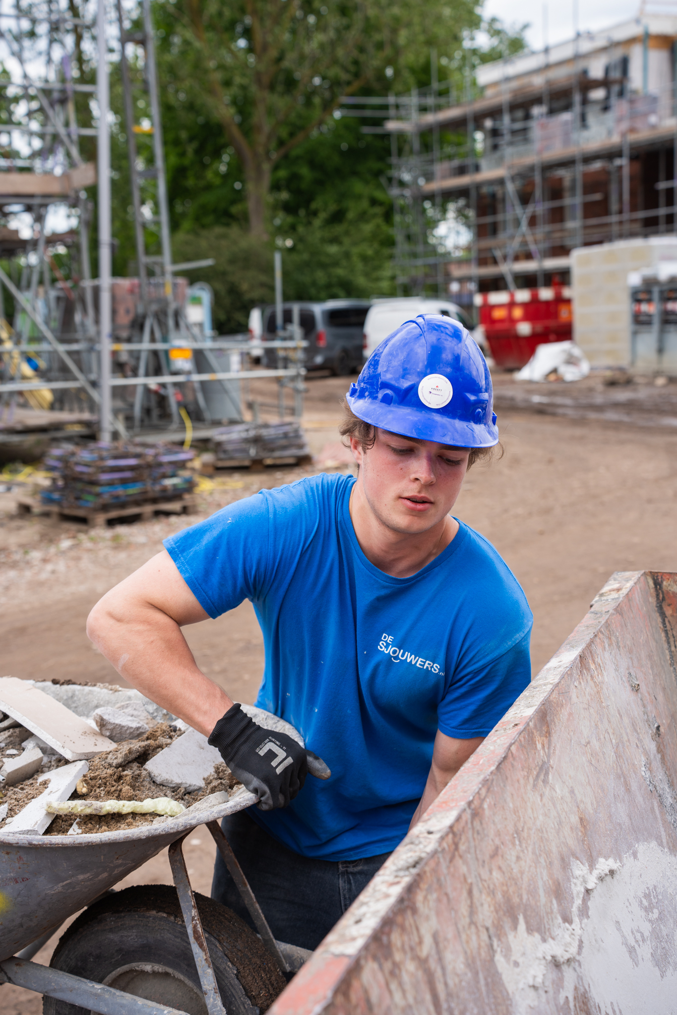 Sjouwer vult containers op de bouw