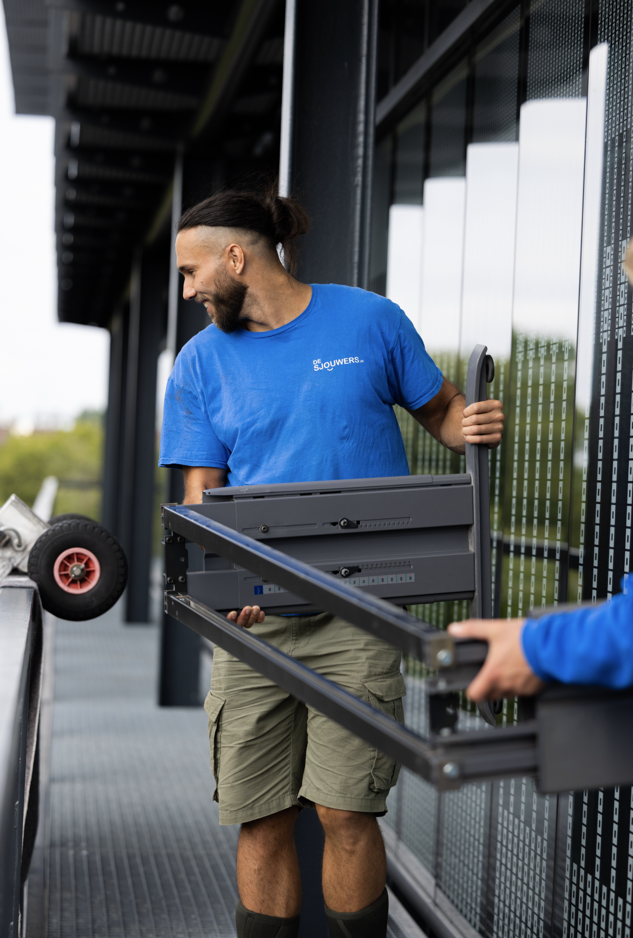 Sjouwer verplaatst metalen frame en apparatuur bij een bedrijfsverhuizing