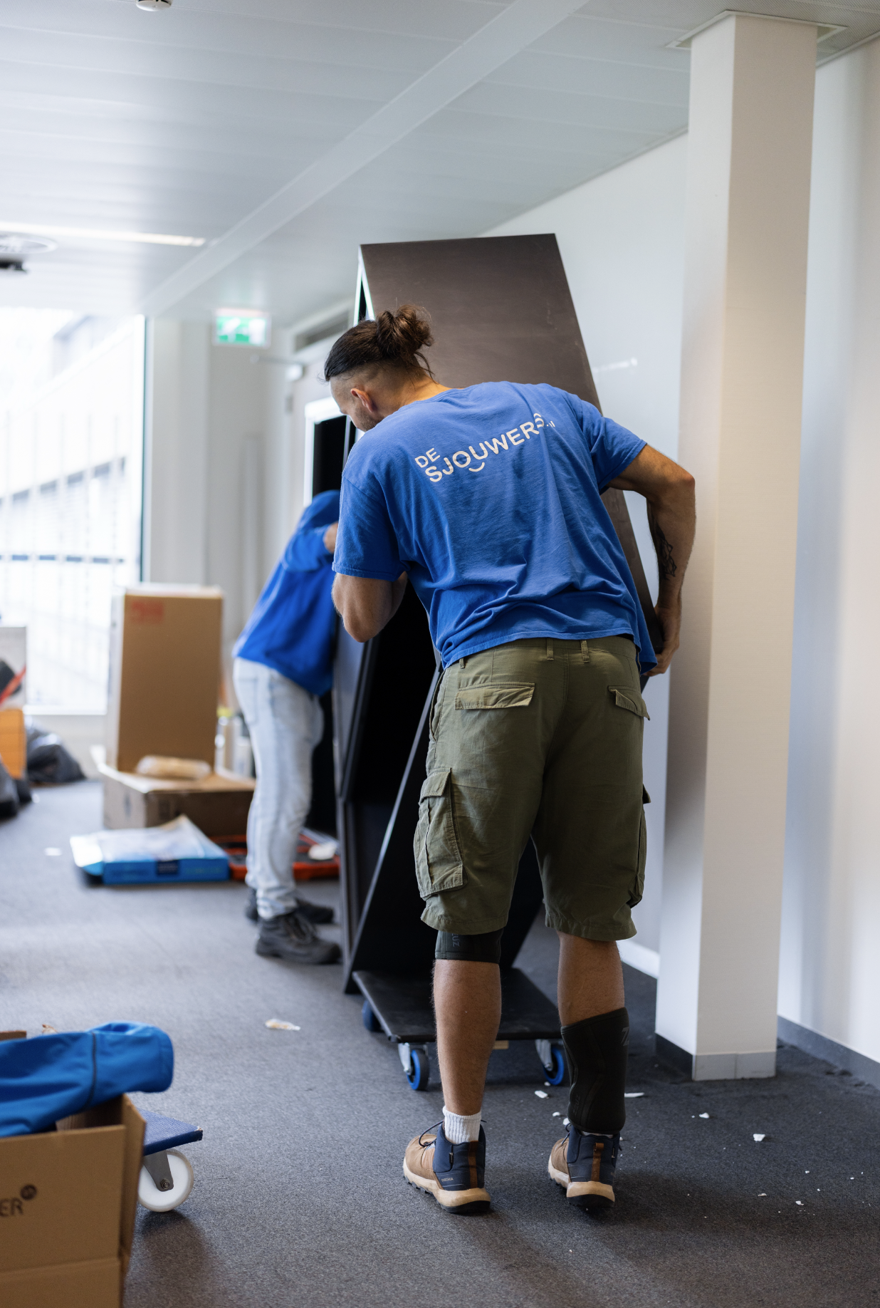 Sjouwers tillen kast bij kantoorverhuizing